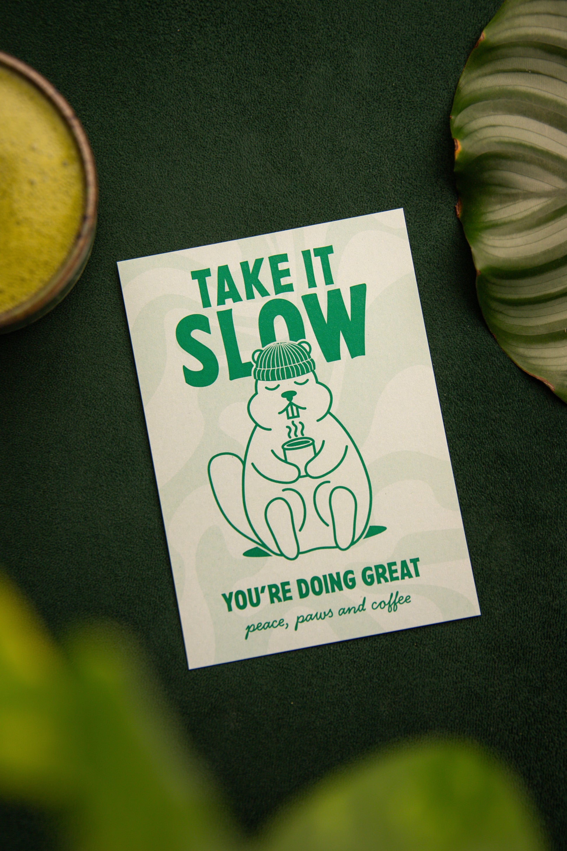 Murmeltierkarte die entspannt und einen Kaffee oder Tee in der Hand hält